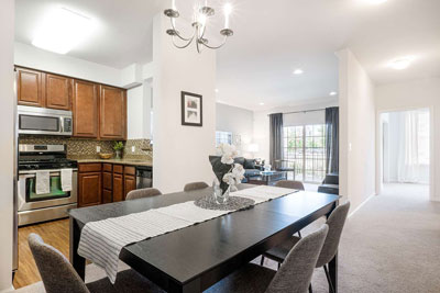 View of apartment dining room and kitchen furnished with kitchen appliances and dining room table